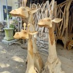 drie uitgesneden giraffen van teakhout