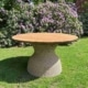 Ronde Ubud tuintafel van massief teakhout met wicker onderstel in groene tuin